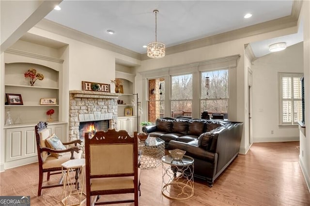 5861 Yoshino Cherry Ln, Braselton, GA 30517 - sitting room featuring crown molding, built in features, a notable chandelier, a fireplace, and light wood-type flooring
