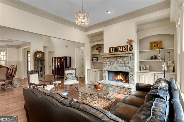 5861 Yoshino Cherry Ln, Braselton, GA 30517 - living room featuring crown molding, built in features, a notable chandelier, a fireplace, and light wood-type flooring