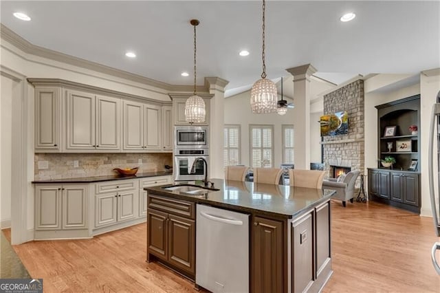 5861 Yoshino Cherry Ln, Braselton, GA 30517 - kitchen featuring appliances with stainless steel finishes, an island with sink, sink, hanging light fixtures, and a brick fireplace