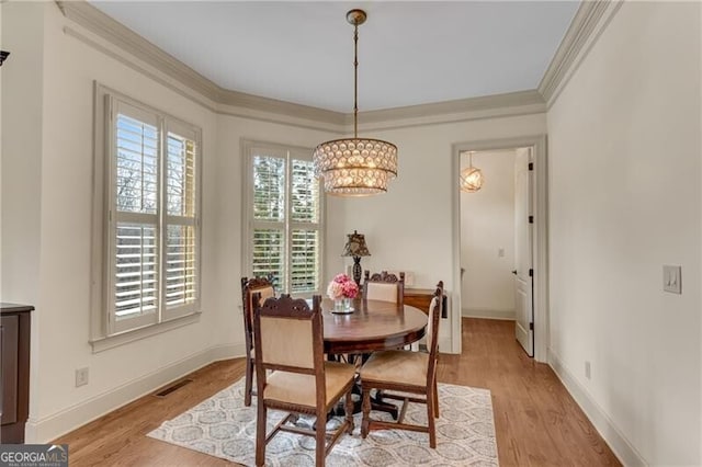 5861 Yoshino Cherry Ln, Braselton, GA 30517 - dining space featuring crown molding, an inviting chandelier, and light hardwood / wood-style floors