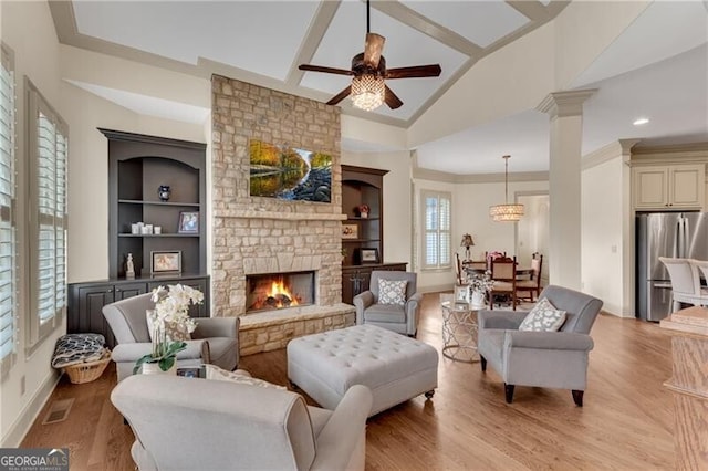 5861 Yoshino Cherry Ln, Braselton, GA 30517 - sitting room featuring a stone fireplace, vaulted ceiling, light wood-type flooring, ornamental molding, and built in features