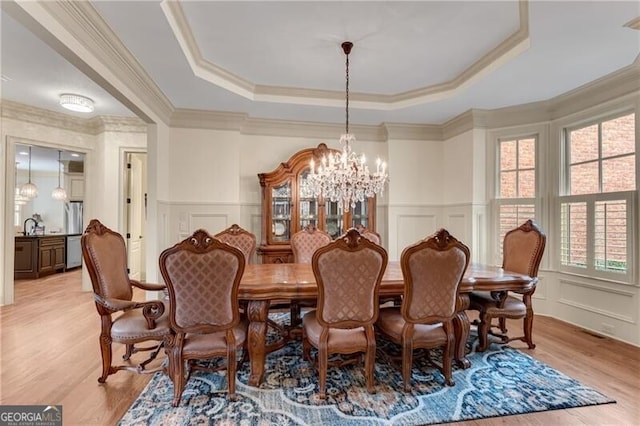 5861 Yoshino Cherry Ln, Braselton, GA 30517 - dining room with an inviting chandelier, ornamental molding, a raised ceiling, and light hardwood / wood-style floors