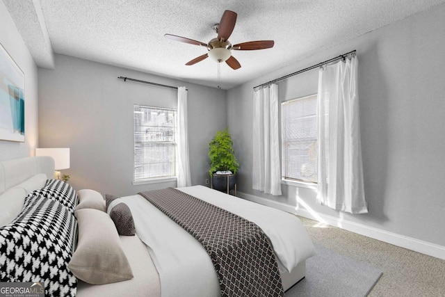 bedroom featuring ceiling fan, carpet flooring, and a textured ceiling