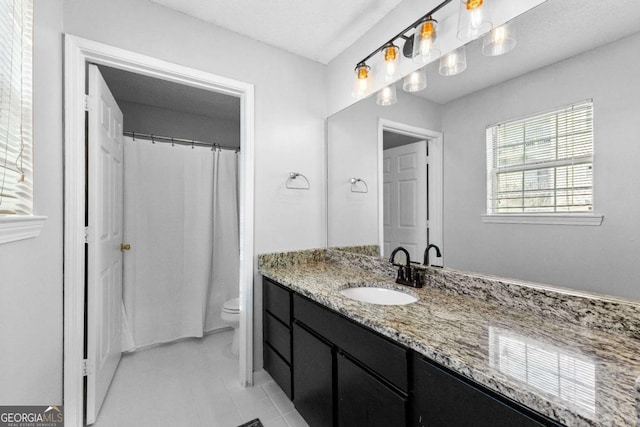 bathroom with tile patterned flooring, vanity, and toilet