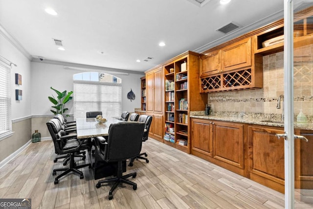 office area with crown molding, sink, and light hardwood / wood-style floors