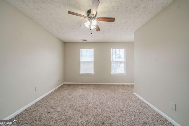 spare room featuring ceiling fan, carpet floors, and a textured ceiling