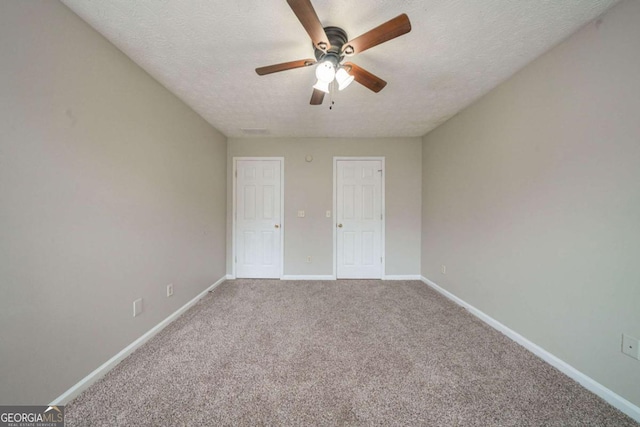 unfurnished bedroom featuring a textured ceiling, carpet flooring, and ceiling fan