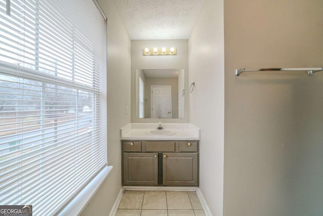 bathroom with a textured ceiling, vanity, and tile patterned flooring