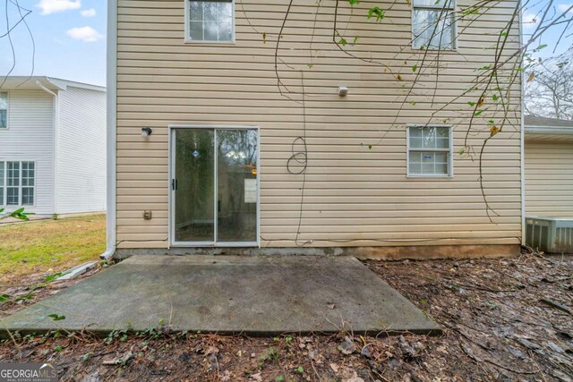 rear view of house with a patio area and cooling unit