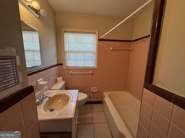 bathroom with vanity, toilet, tile patterned flooring, and tile walls