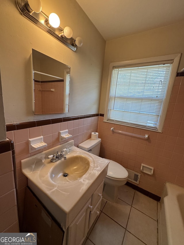 full bathroom featuring tile patterned flooring, vanity, tile walls, and toilet