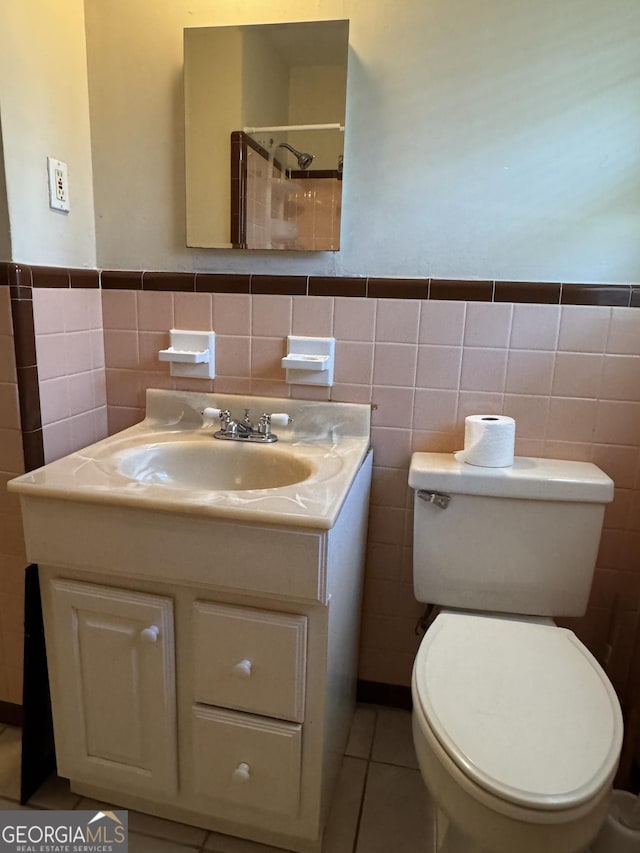 bathroom featuring vanity, tile patterned flooring, tile walls, and toilet