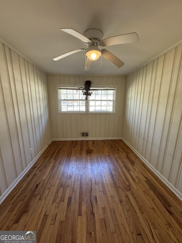 empty room featuring ceiling fan and dark hardwood / wood-style flooring