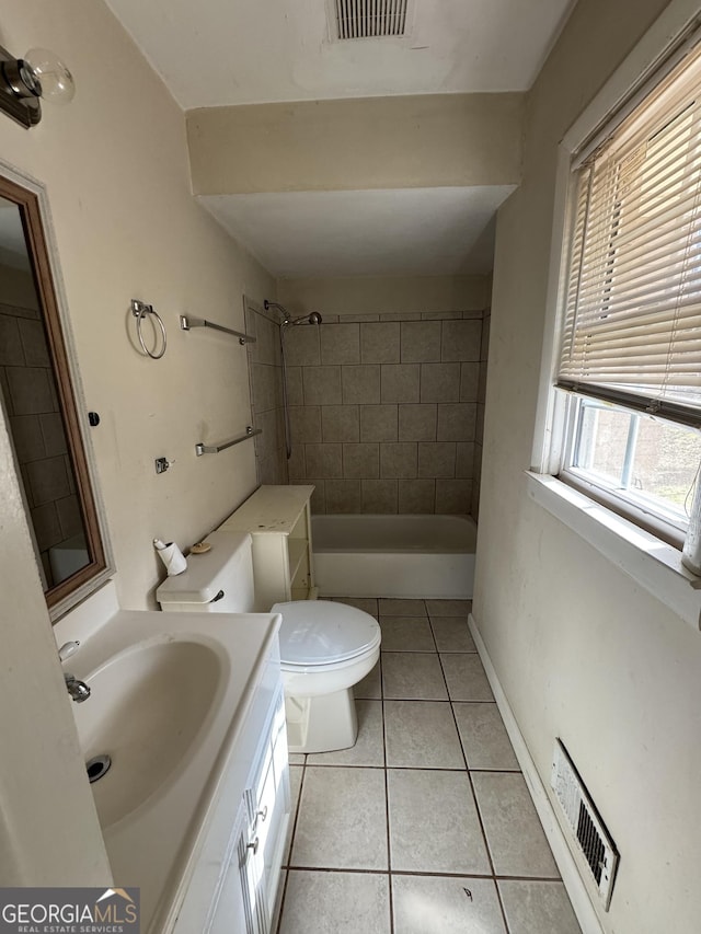 bathroom with vanity, tile patterned floors, toilet, and a tile shower