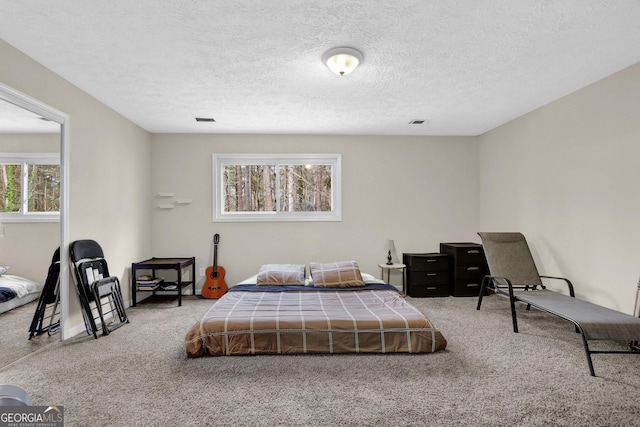 carpeted bedroom with a textured ceiling and visible vents