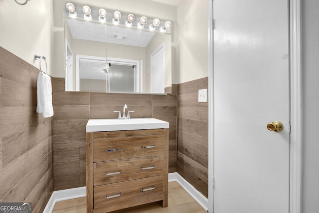 bathroom with visible vents, tile walls, and vanity