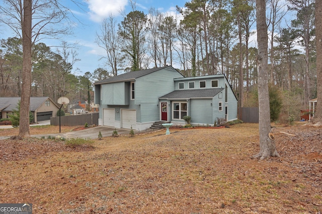 view of front of house featuring a garage, driveway, and fence