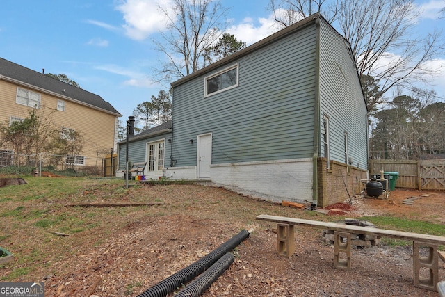 exterior space with fence, french doors, and brick siding