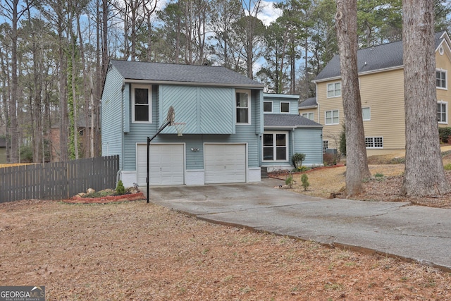 view of front of home featuring concrete driveway, roof with shingles, fence, and an attached garage