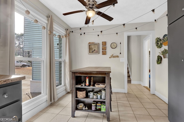 dining area with ceiling fan, stairway, baseboards, and light tile patterned floors