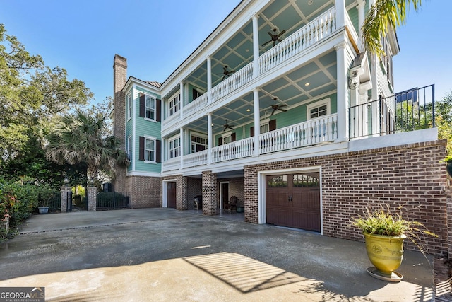 view of front of property with a garage, a balcony, and ceiling fan