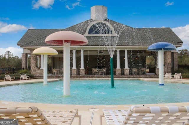 view of pool with a patio and pool water feature