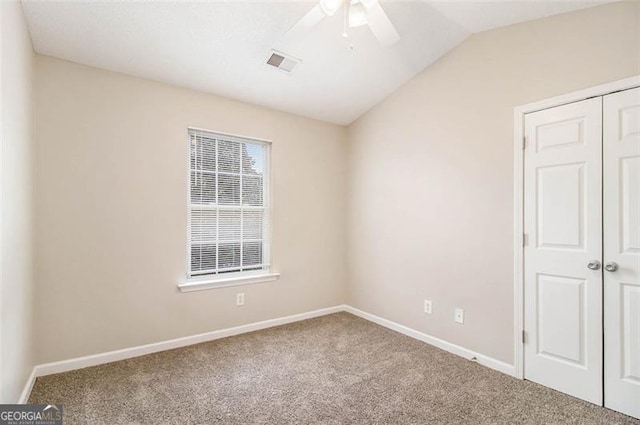 carpeted empty room featuring ceiling fan and lofted ceiling