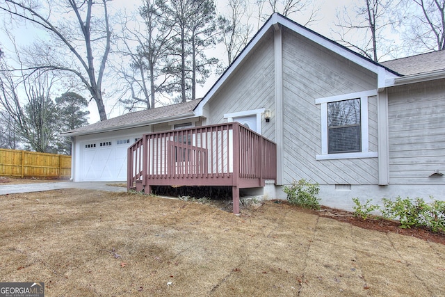 view of front of home with a garage, a deck, and a front lawn