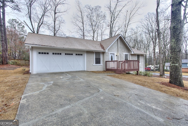 single story home with a garage and a wooden deck