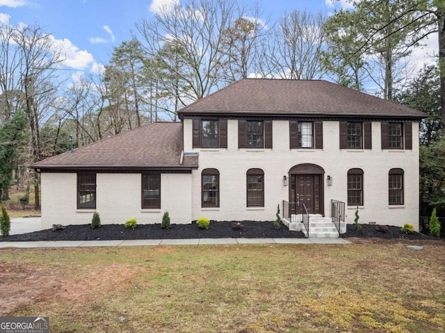 colonial inspired home with a front lawn