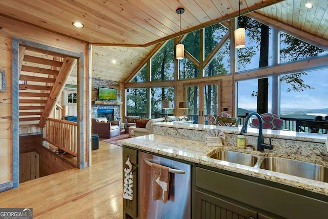 kitchen with pendant lighting, sink, dishwasher, light stone countertops, and wooden ceiling