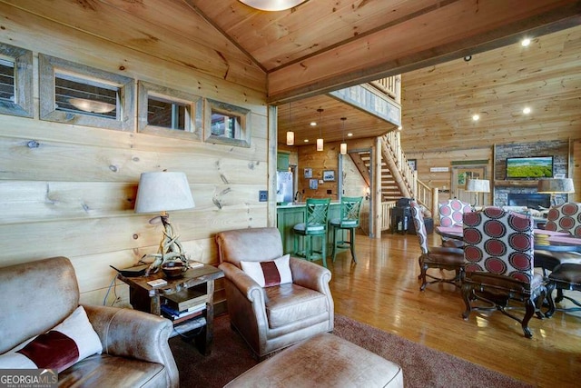 living room with lofted ceiling, wood ceiling, hardwood / wood-style flooring, a fireplace, and wood walls