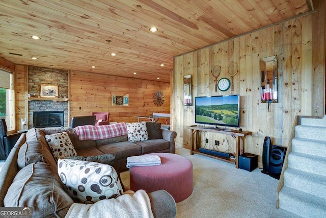 living room featuring carpet, a stone fireplace, wood ceiling, and wood walls