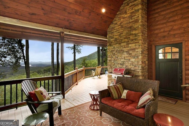 wooden deck with a mountain view, a grill, and outdoor lounge area