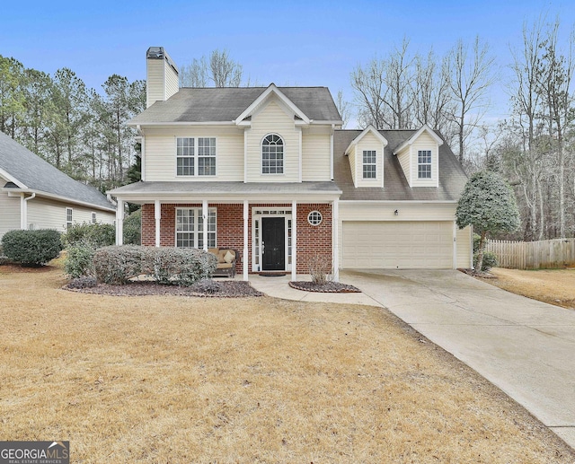 front facade with a garage, a front yard, and covered porch