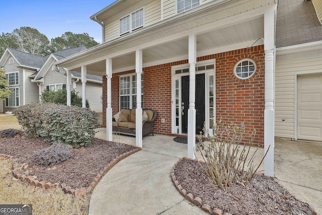 doorway to property with a garage and a porch