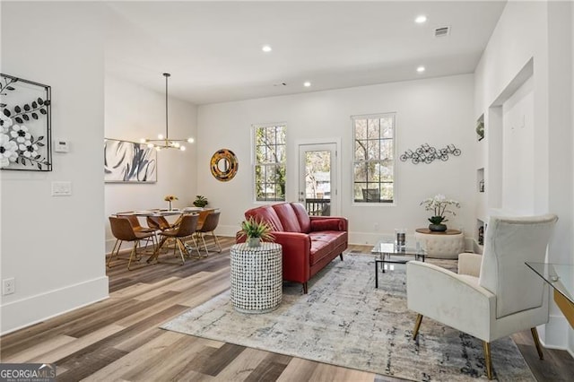 living area with visible vents, a notable chandelier, wood finished floors, recessed lighting, and baseboards