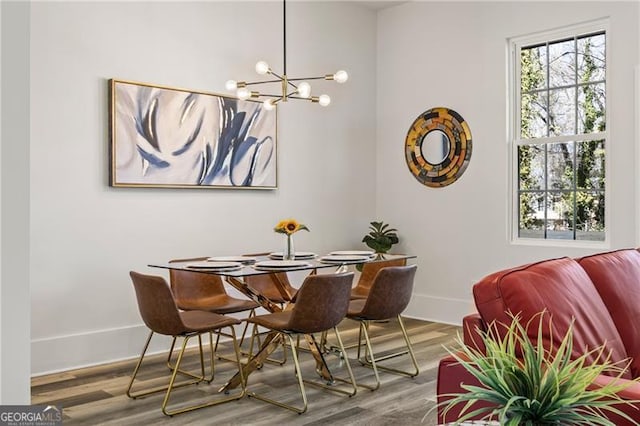 dining area featuring a notable chandelier, wood finished floors, and baseboards