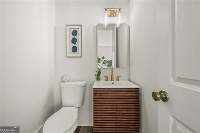 half bathroom with toilet and vanity