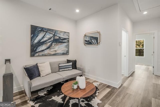 sitting room featuring wood finished floors, visible vents, baseboards, attic access, and recessed lighting