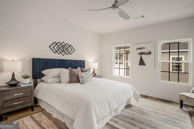bedroom featuring visible vents, a ceiling fan, and wood finished floors