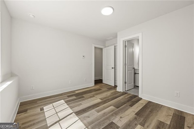 unfurnished bedroom featuring wood finished floors and baseboards