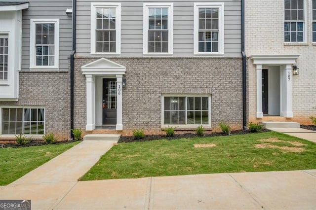 view of front facade with a front yard and brick siding
