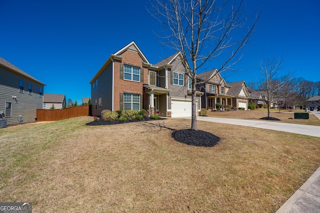 traditional home featuring brick siding, fence, a residential view, driveway, and a front lawn