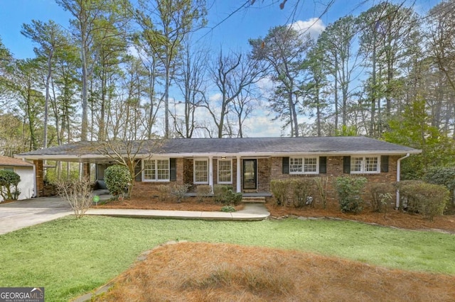 ranch-style home with concrete driveway, brick siding, and a front lawn