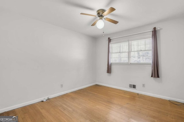 empty room featuring light wood-type flooring, baseboards, visible vents, and ceiling fan