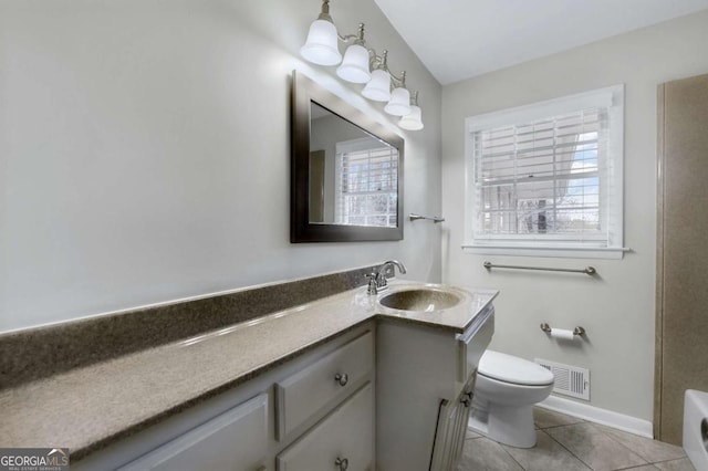 bathroom with visible vents, toilet, tile patterned floors, vanity, and a healthy amount of sunlight