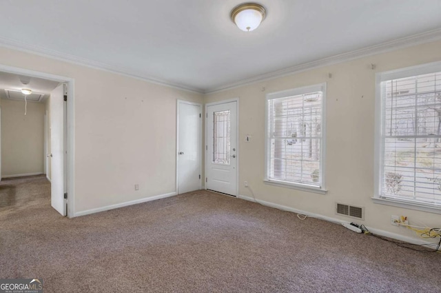 interior space with attic access, baseboards, visible vents, crown molding, and carpet floors