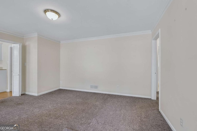 interior space with carpet, visible vents, ornamental molding, and baseboards