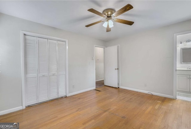 unfurnished bedroom with ensuite bathroom, light wood finished floors, a closet, and baseboards